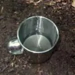 Das saubere, gefilterte Wasser in einem Edelstahlbecher. Mit dem PET-Wasserfilter wird das zuvor dreckige Wasser sichtbar gereinigt und verwertbar.