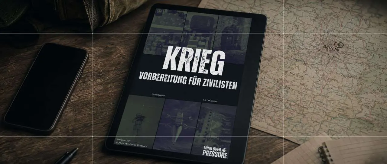 Das Buch "Krieg - Vorbereitung für Zivilisten" liegt auf einer Landkarte, neben einem Notizblock auf der einen und einem Telefon auf der anderen Seite auf einem Schreibtisch